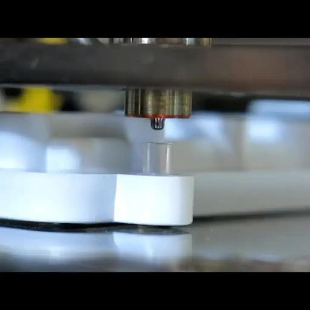 Precision machining process featuring a close-up of a machining tool above a white plastic component, illustrating manufacturing techniques relevant to electroplating and plastic machining services.